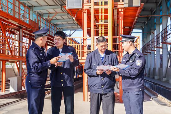 刑警支隊(duì)民警向企業(yè)職工發(fā)放宣傳資料并“一對(duì)一”講解電詐常識(shí)。謝仁古力·托呼提 攝